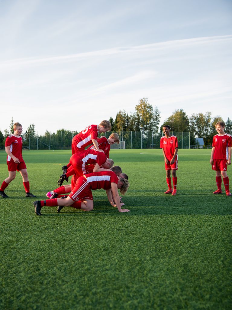 Glada fotbollskillar som hänger på fotbollsplanen.