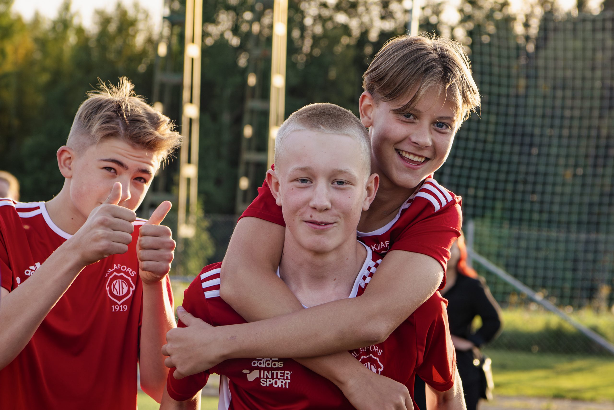 Fotbolls killar i matchställ som har kul tillsammans