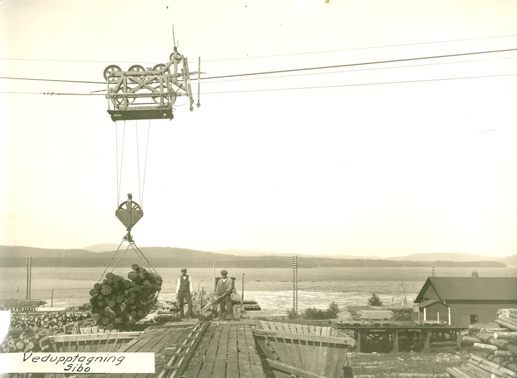 Historisk bild på kabelkranen som lyfter timmer.
